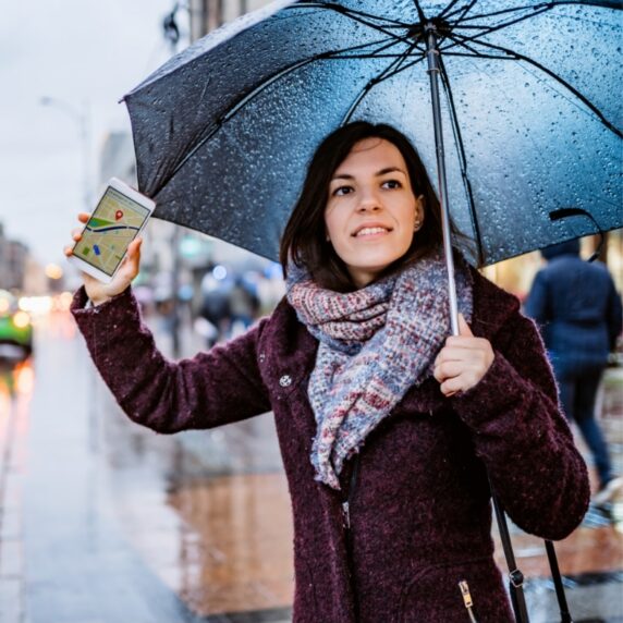 a woman holding an umbrella hailing for a ride