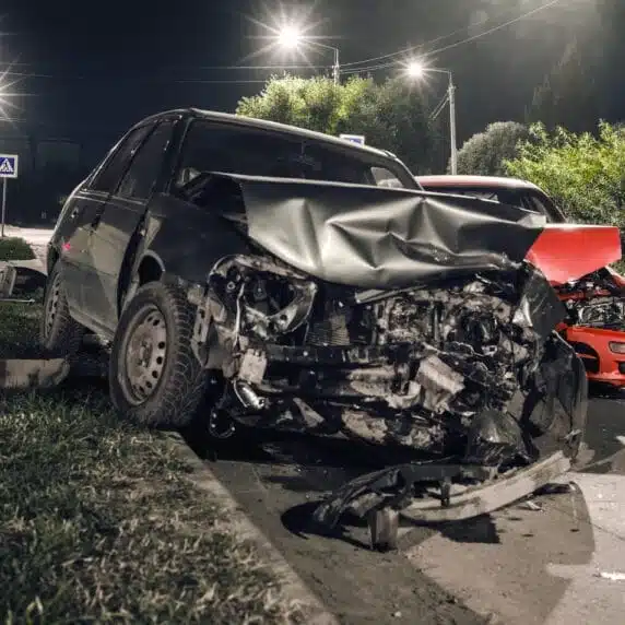 Wrecked black car and a red car after a severe car accident.