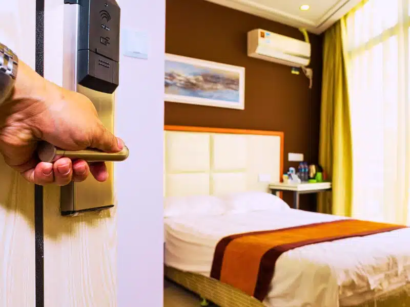 Hand opening a hotel room door with handle. Sue a casino or hotel for enabling sex trafficking
