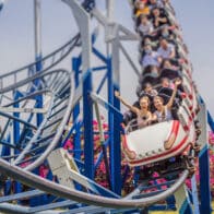 people on a roller coaster at an amusement park